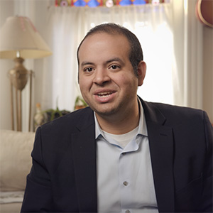 Portrait of Eric Garcia speaking, wearing a dark blazer