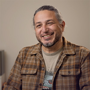 Portrait of Ivan Vejar smiling, wearing a plaid shirt