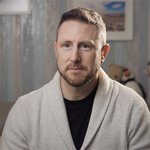 Portrait of Jordan James wearing a light grey cardigan